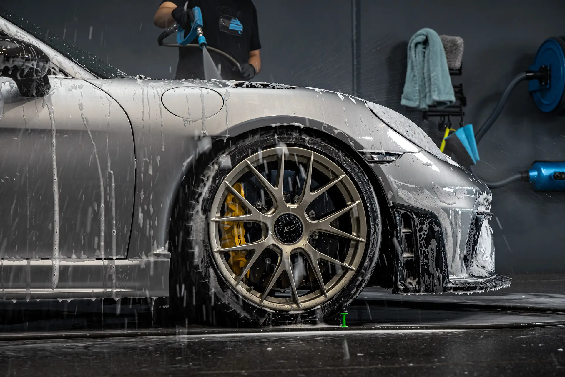 Rinsing a foam-covered Porsche