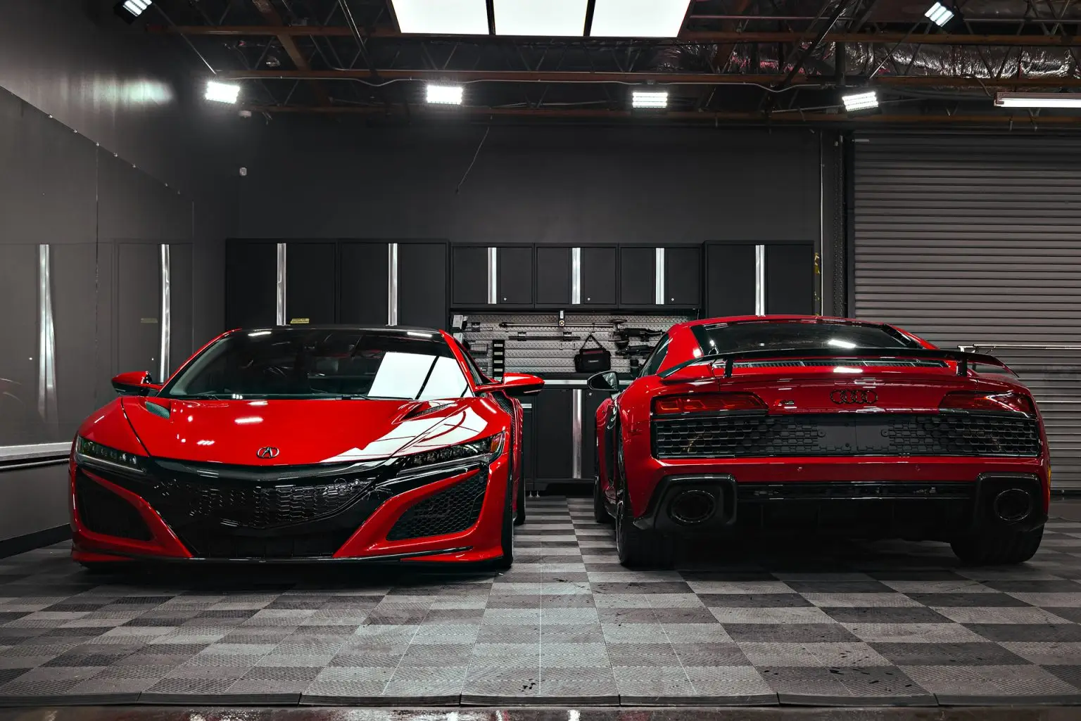 Red Acura NSX beside a red Audi R8 in the ST6 detail bay