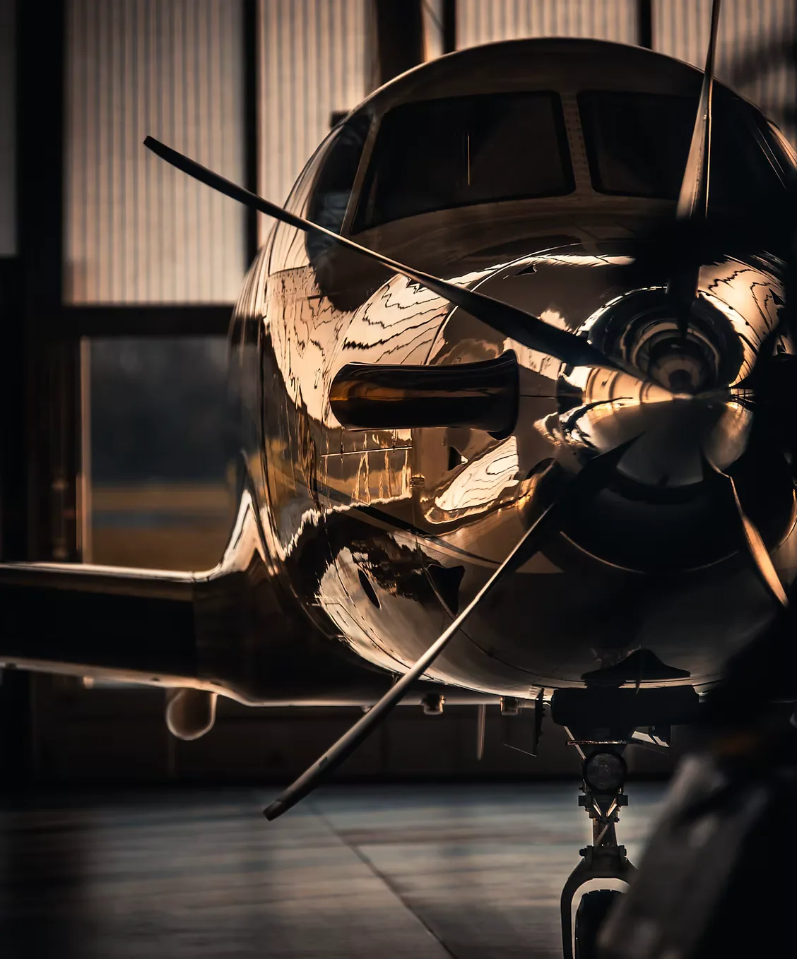 Propeller and cowling of an aircraft with a showroom finish in a dimly lit hangar