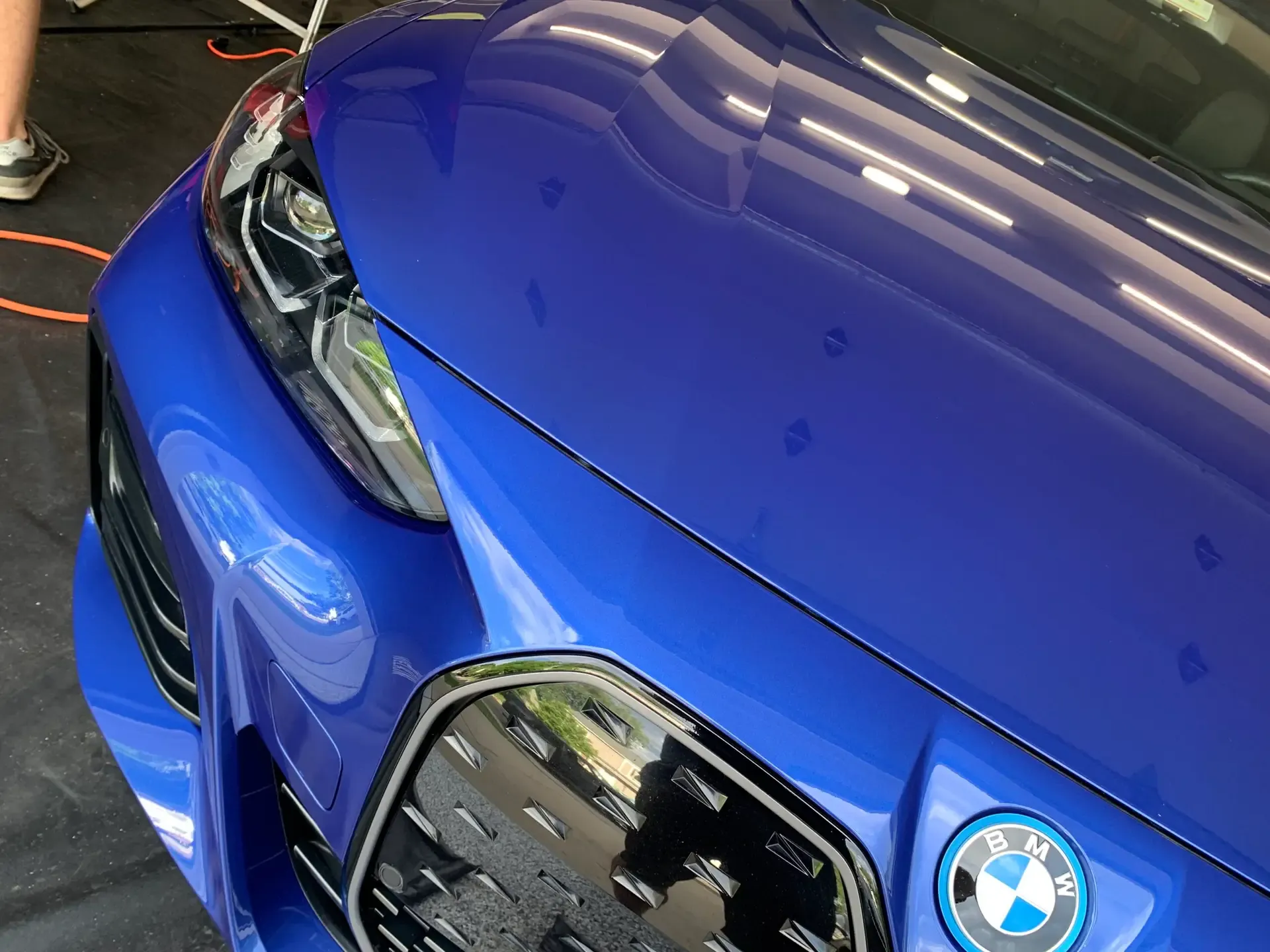 Blue BMW front end with water beading across the hood after a hand wash by ST6 Detailers