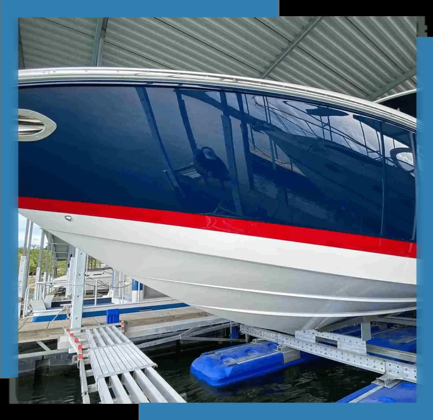 Clean blue and white hull with a red stripe resting on a boat lift under a covered slip