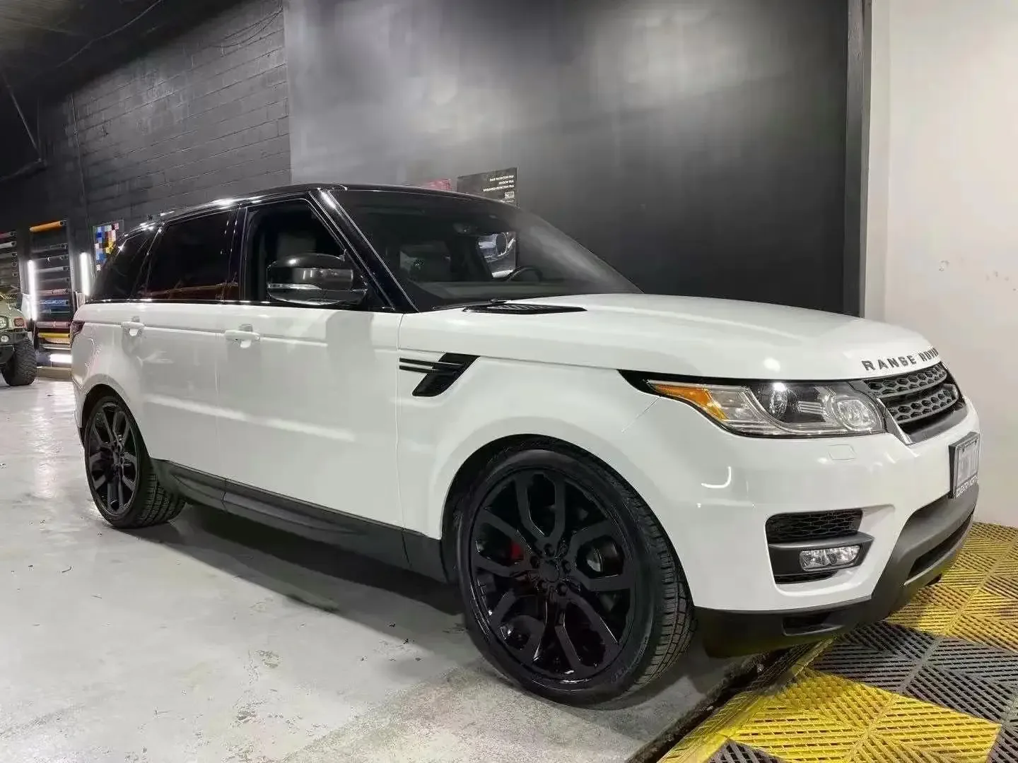White Range Rover Sport with blacked-out trim and dark wheels in the ST6 Detailers bay
