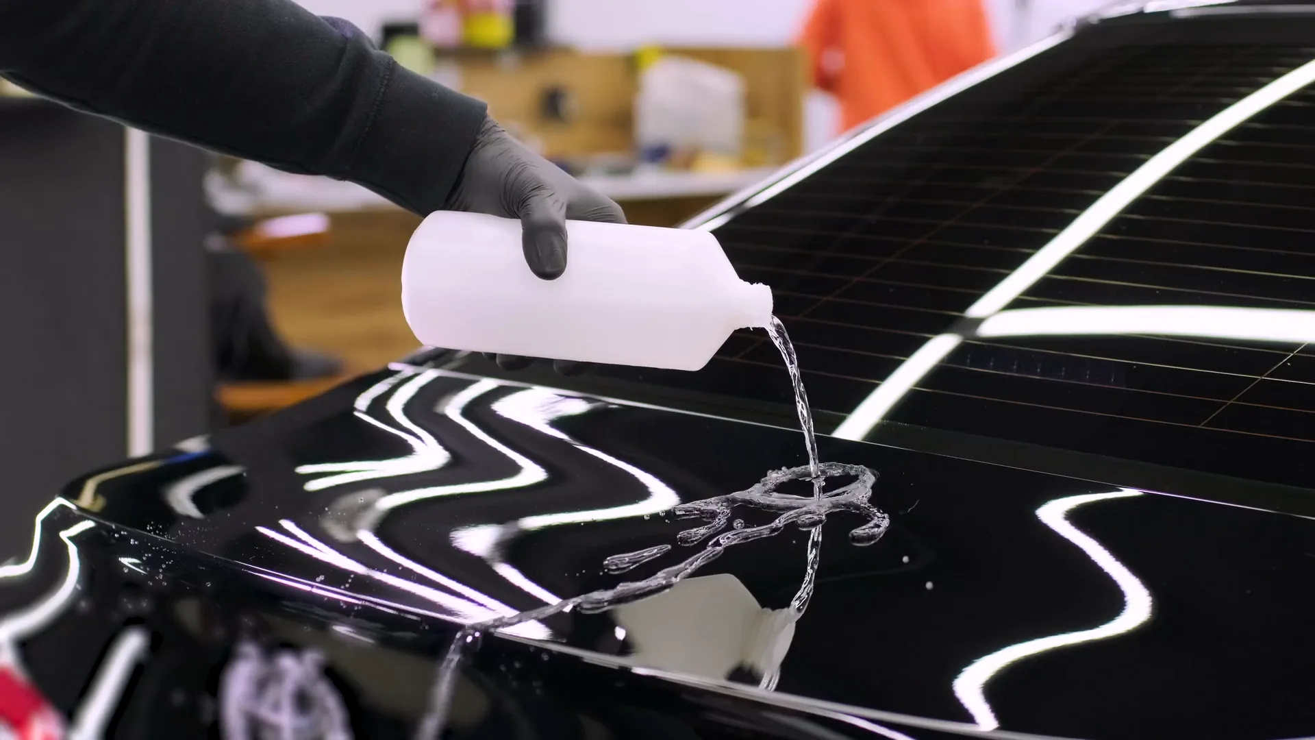 Water poured onto a coated gloss-black hood beading and sheeting off at ST6 Detailers