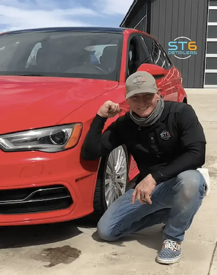 Dana Starr, owner of ST6 Detailers, beside a red Audi