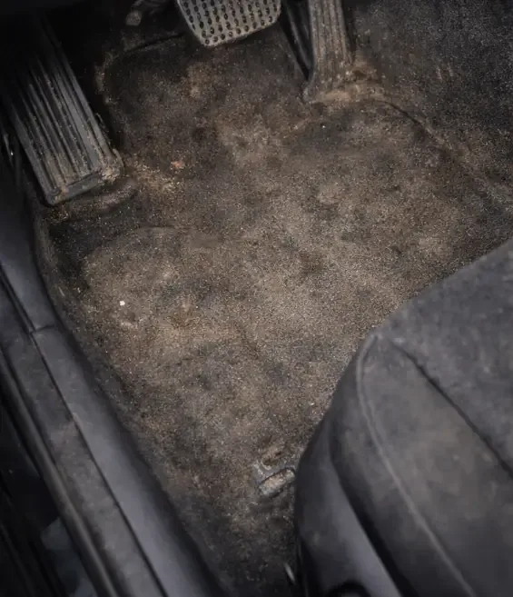 Driver footwell carpet caked in dirt before cleaning