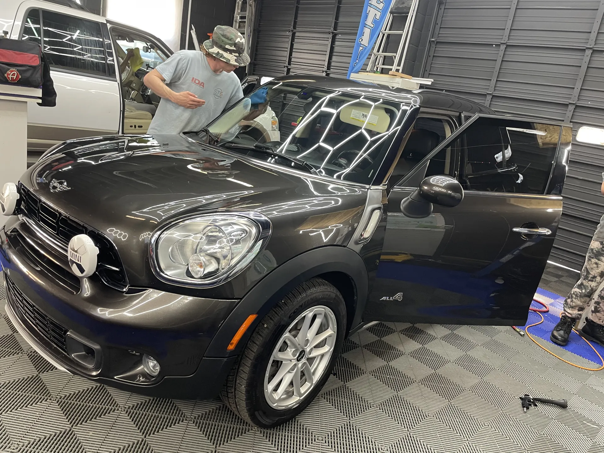 ST6 technician detailing a black MINI Cooper Countryman in the shop