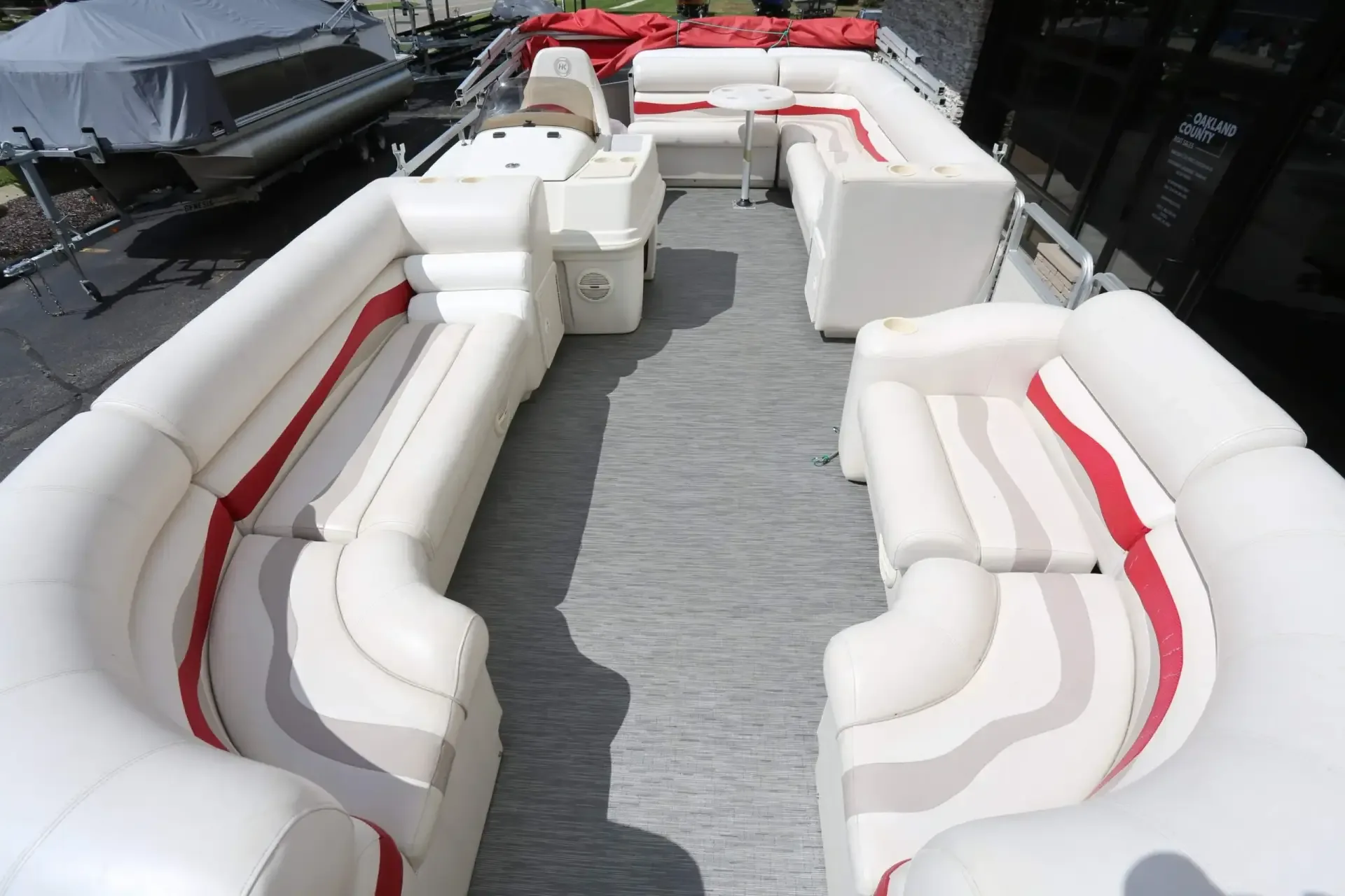Pontoon deck with white and red vinyl lounge seating and grey carpet after cleaning