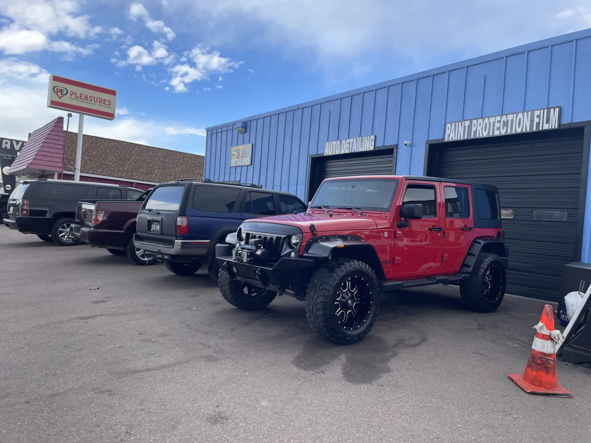 The ST6 Detailers shop on N Nevada Ave: blue metal building under Auto Detailing and Paint Protection Film signage, with detailed vehicles parked out front
