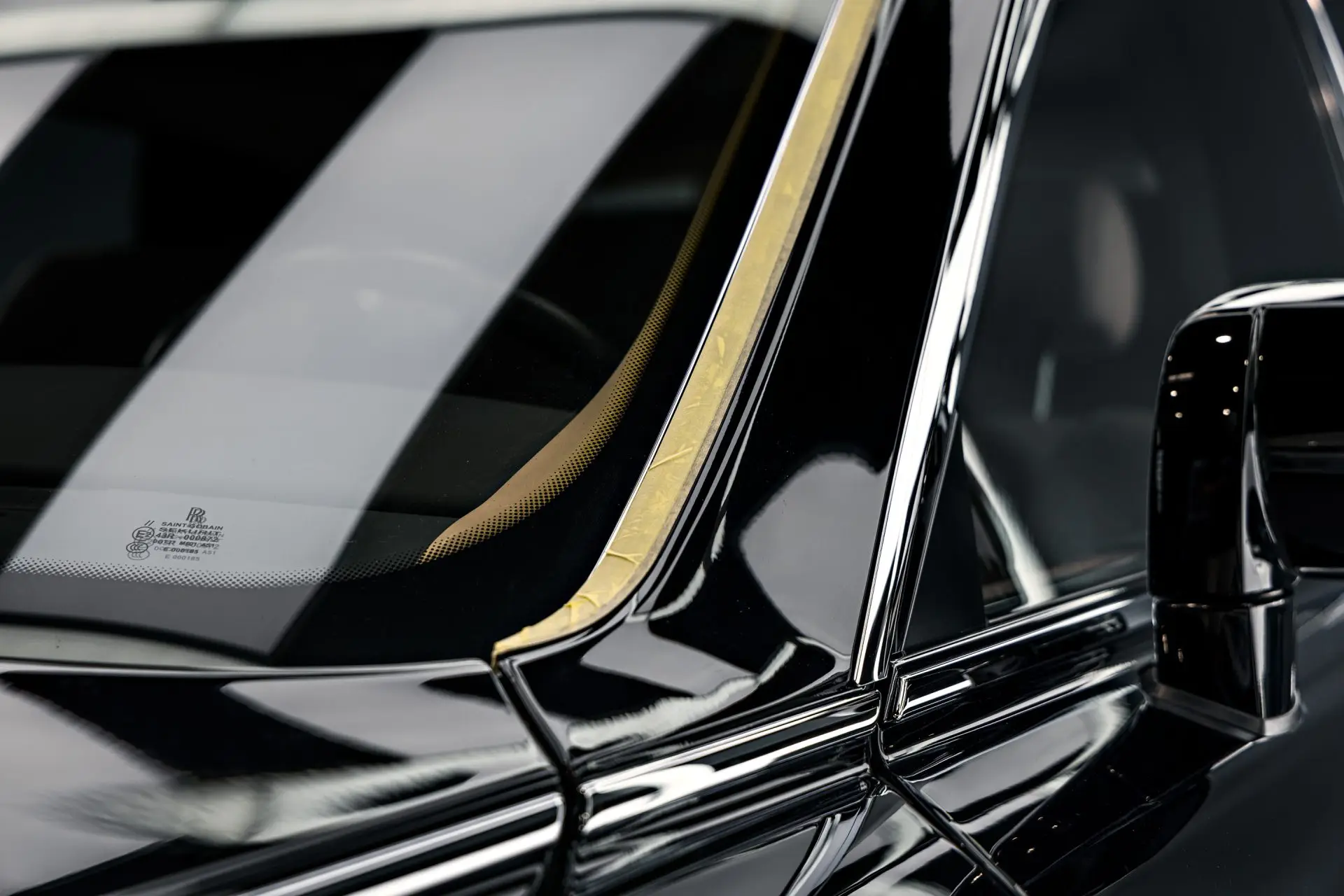 Gold coachline along the shoulder of a black Rolls-Royce Phantom