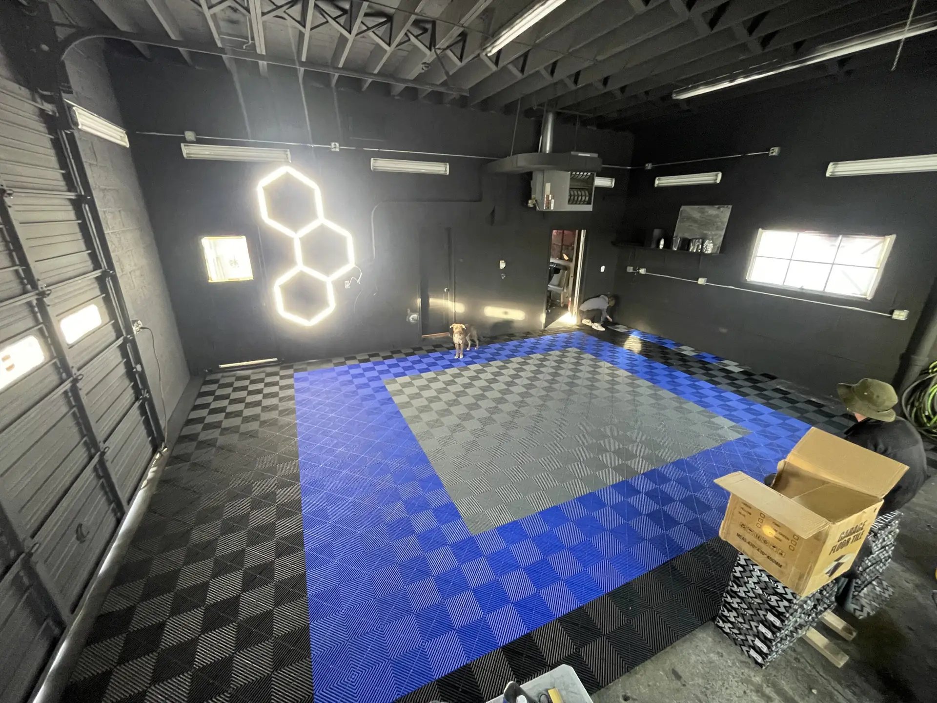 Empty ST6 Detailers bay with blue and grey checkered floor tiles and hexagon LED ceiling lighting
