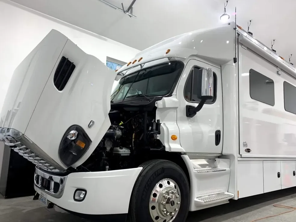 White motorhome on a truck-style cab with the hood raised