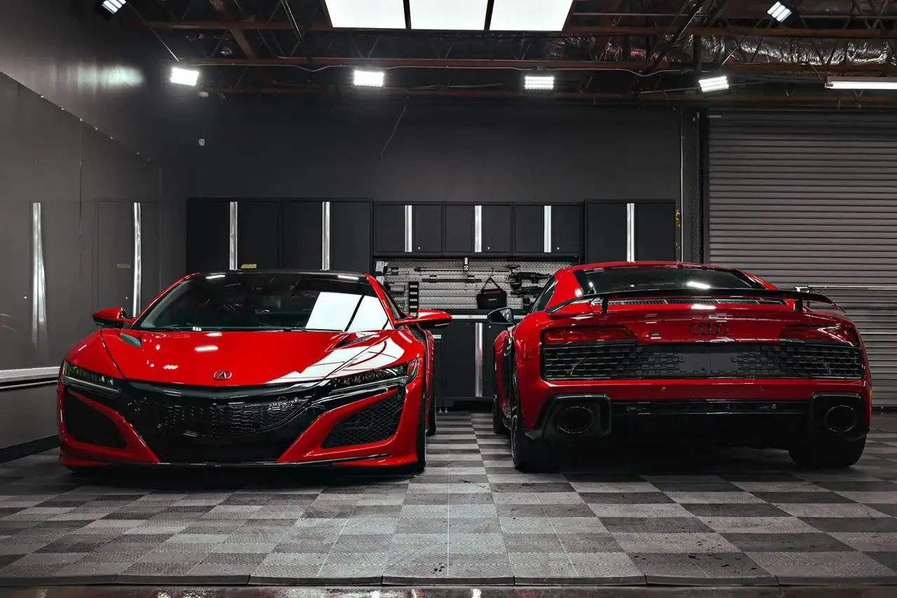 Red Acura NSX beside a red Audi R8 in the ST6 detail bay